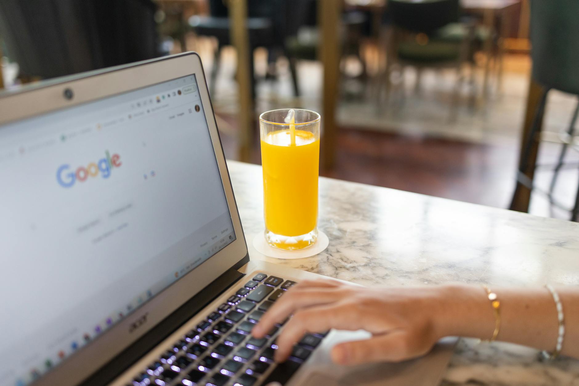 woman using a computer laptop near a glass of juice